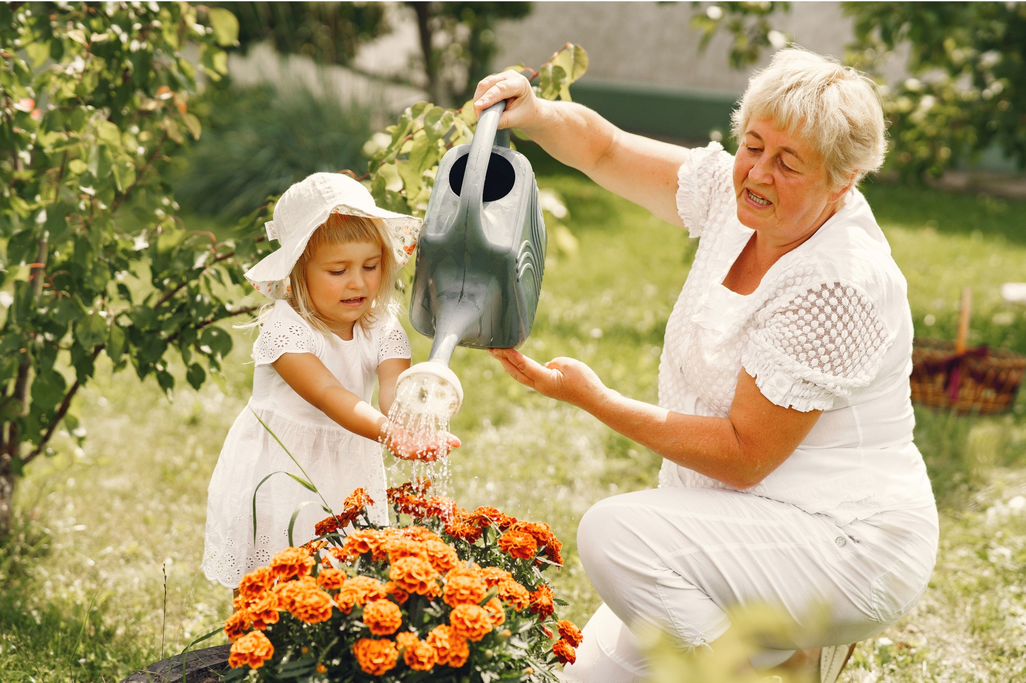 Grandmother and Granddaughter Watering Garden Plants